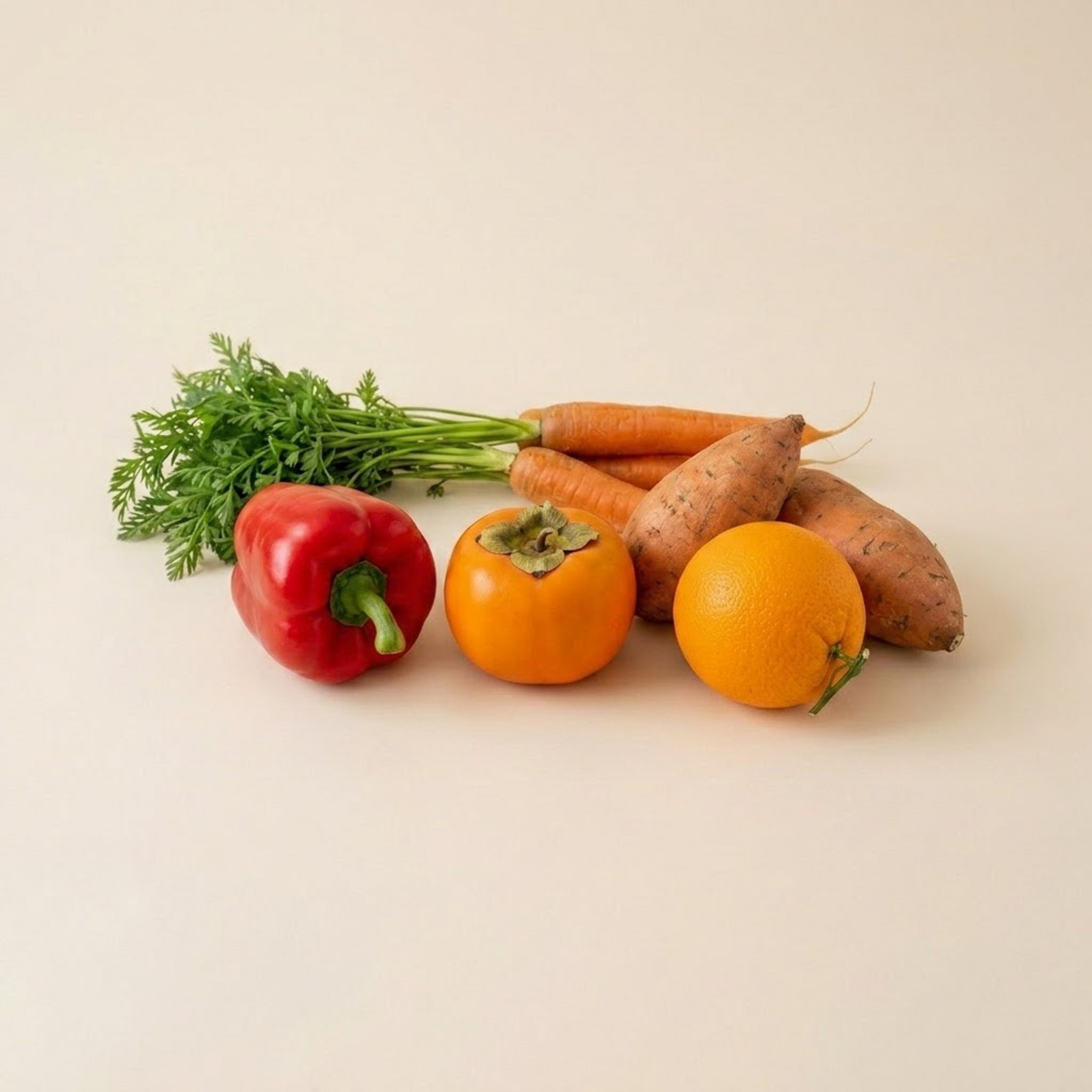 Orange grøntsager og frugter som gulerødder, peberfrugt, søde kartofler og appelsin